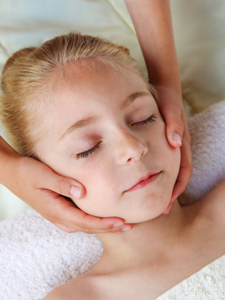 Child getting a mini massage at the Tranquil Tides spa at Manta Island Resort.