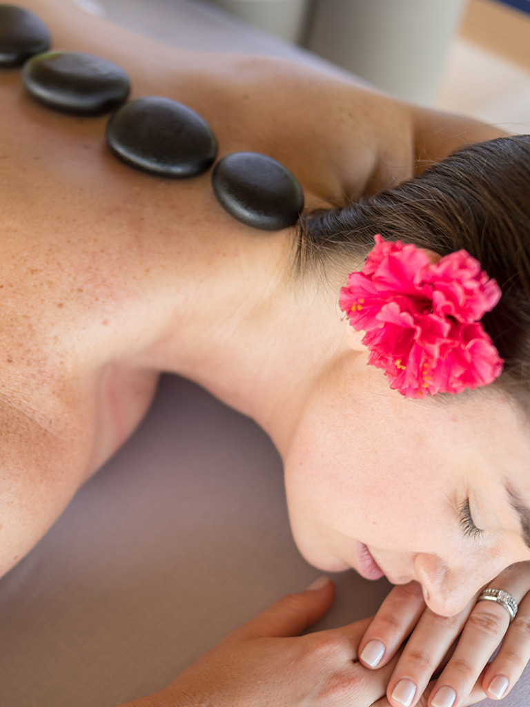 Woman with hot stones on her back during a hot stone massage.