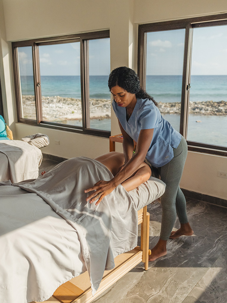 Masseuse is giving a Tranquil Tides Signature Swedish massage to guest.