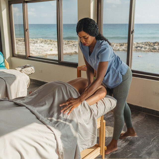 Masseuse is giving a Tranquil Tides Signature Swedish massage to guest.