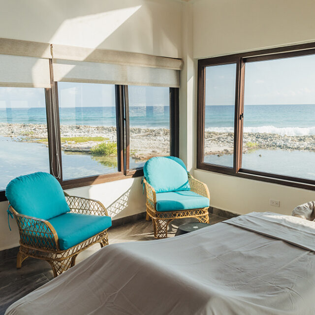 A massage bed and two lounge seats in the Tranquil Tides Spa with reef views.