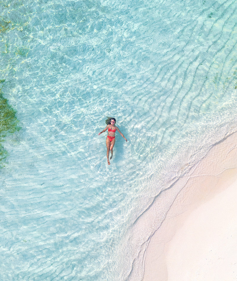 Woman floating in Caribbean waters surround Manta, Belize