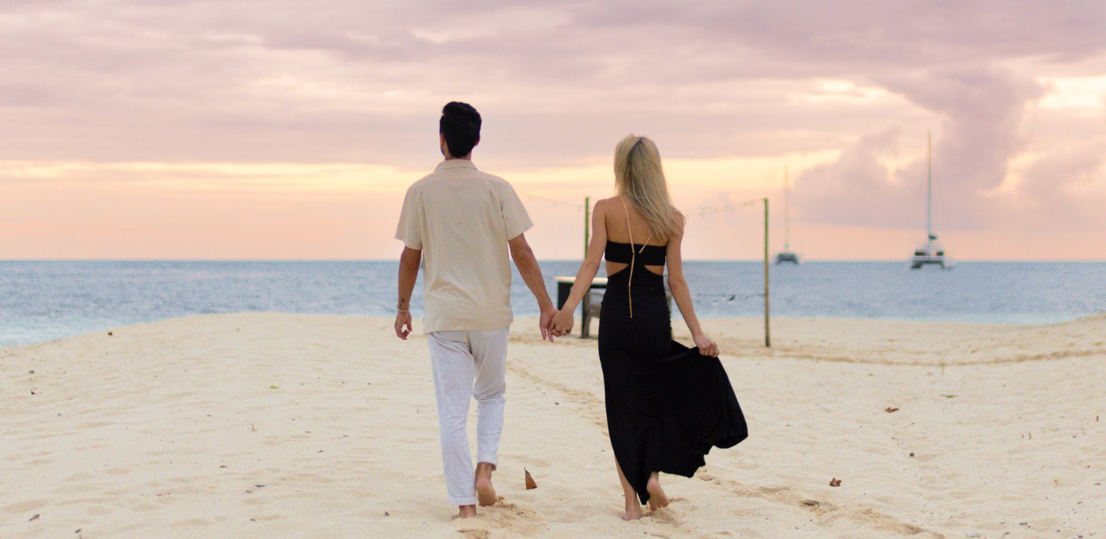 Couple walking along beach at Manta Island Belize