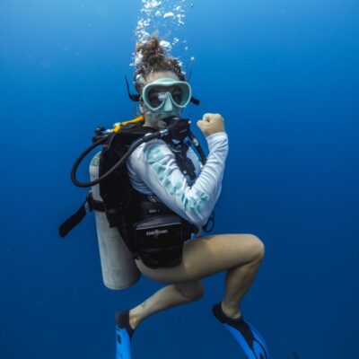Female scuba diver underwater in Belize clear blue ocean