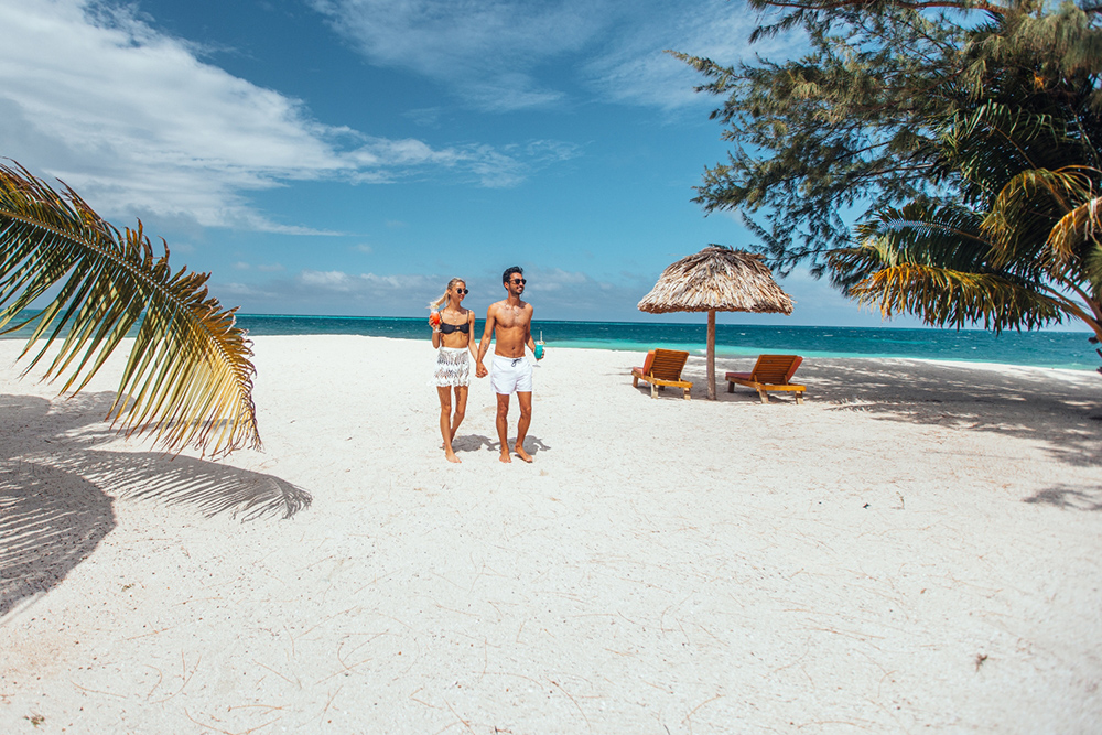 Couple walking beach at Manta Island Resort Belize